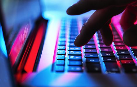 Man typing at his laptop computer at night